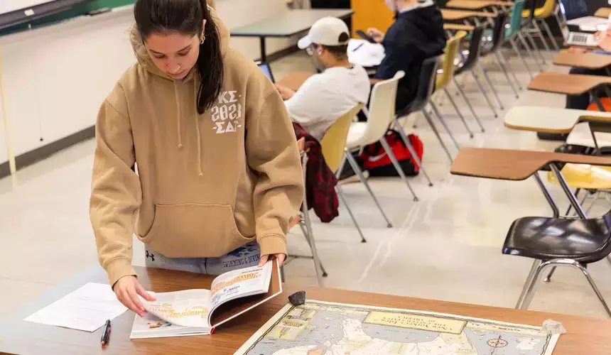Geography student reviewing maps in Geography class
