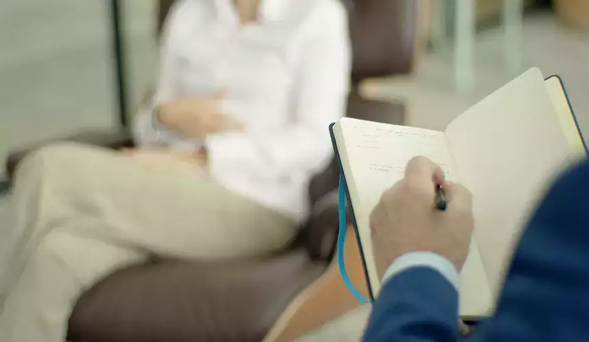 Counselor takes notes during a session