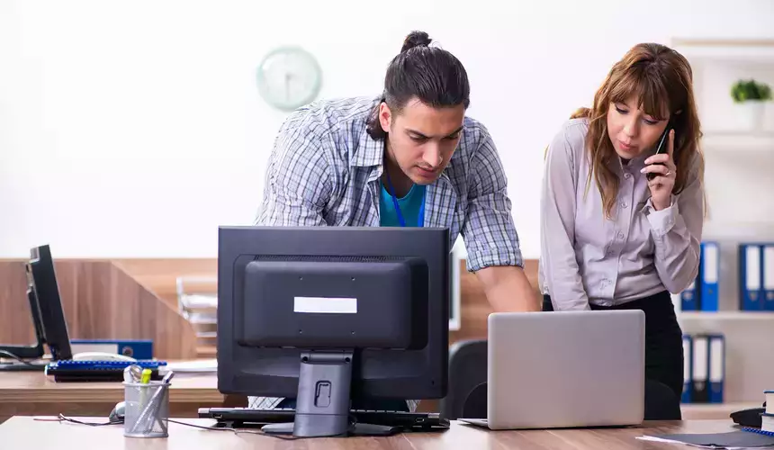 IT Desktop support representative assisting a coworker