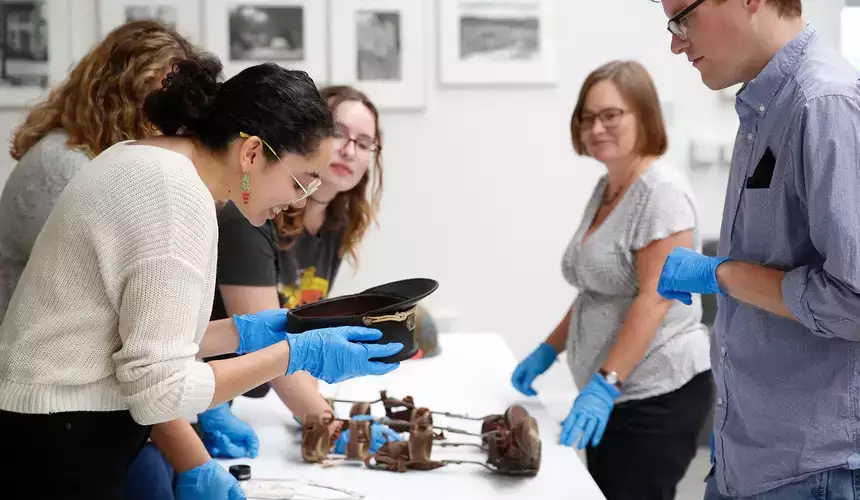 Student in the Cooperstown Museum Studies program examine artifacts.