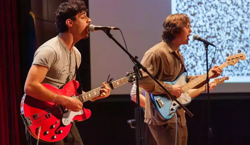 Two young men playing guitars at O Factor competition.