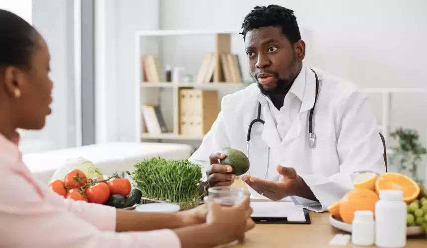 Nutrition and Dietetics expert showing microgreens to female client in clinic
