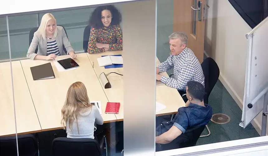 High angle view of businessmen and women having meeting at conference table