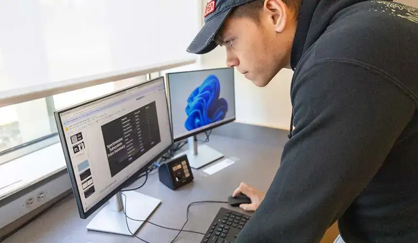 Student with physics software on two monitors.