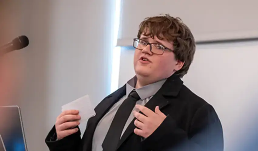 New Visions student and future SUNY Oneonta Red Dragon, Zebb Henness, presenting at the symposium