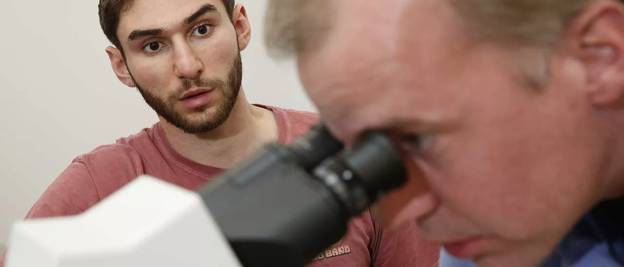 Dr. Florian Reyda looks through a microscope