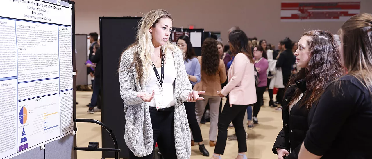 Briana Camassa presents her poster at the 2018 SUNY Undergraduate Research Conference.