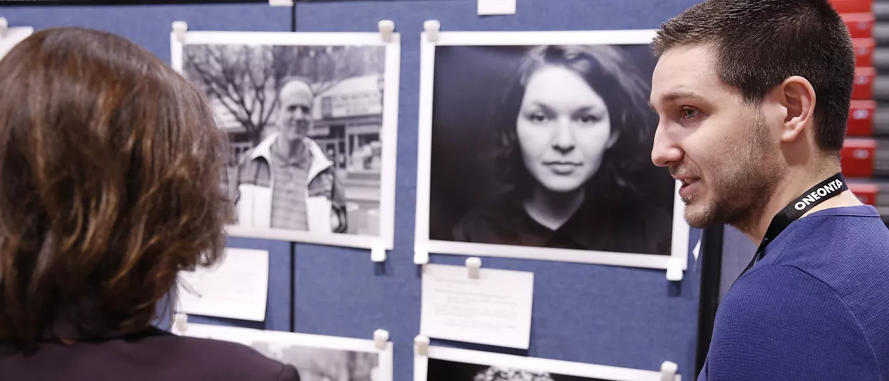 Student presenting photography at a conference.