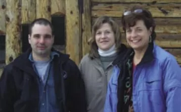 Tim, Tracey, and Colleen standing outside of one of the cabins