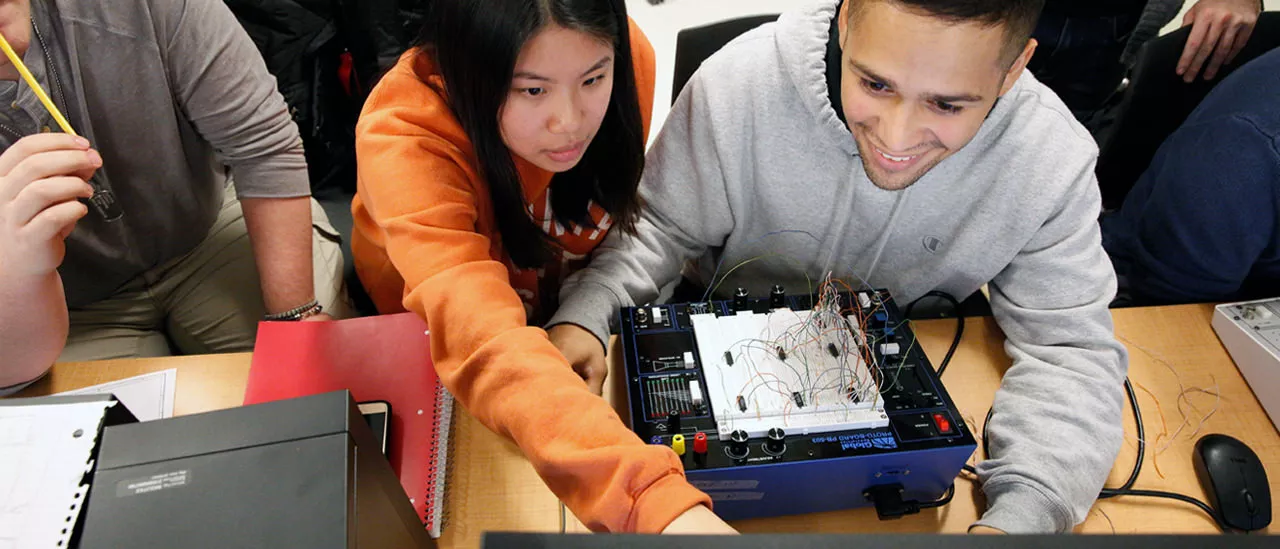 Students working together on wiring a computer.