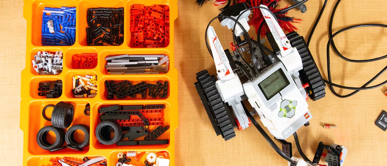 Robot parts in a tray on a desk.