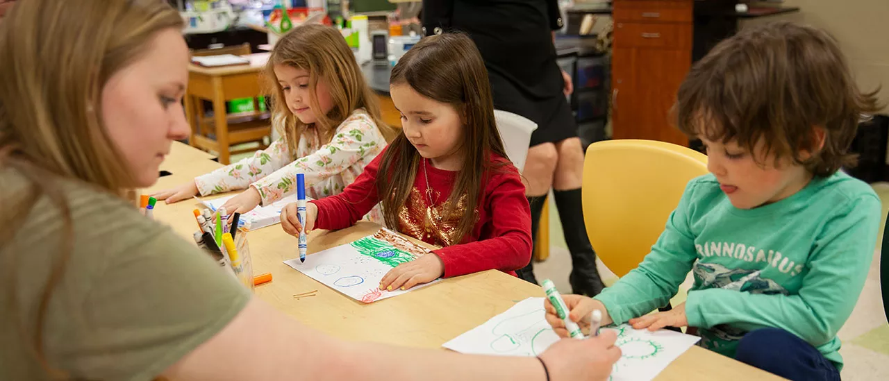 Elementary Education student teaching children how to draw.