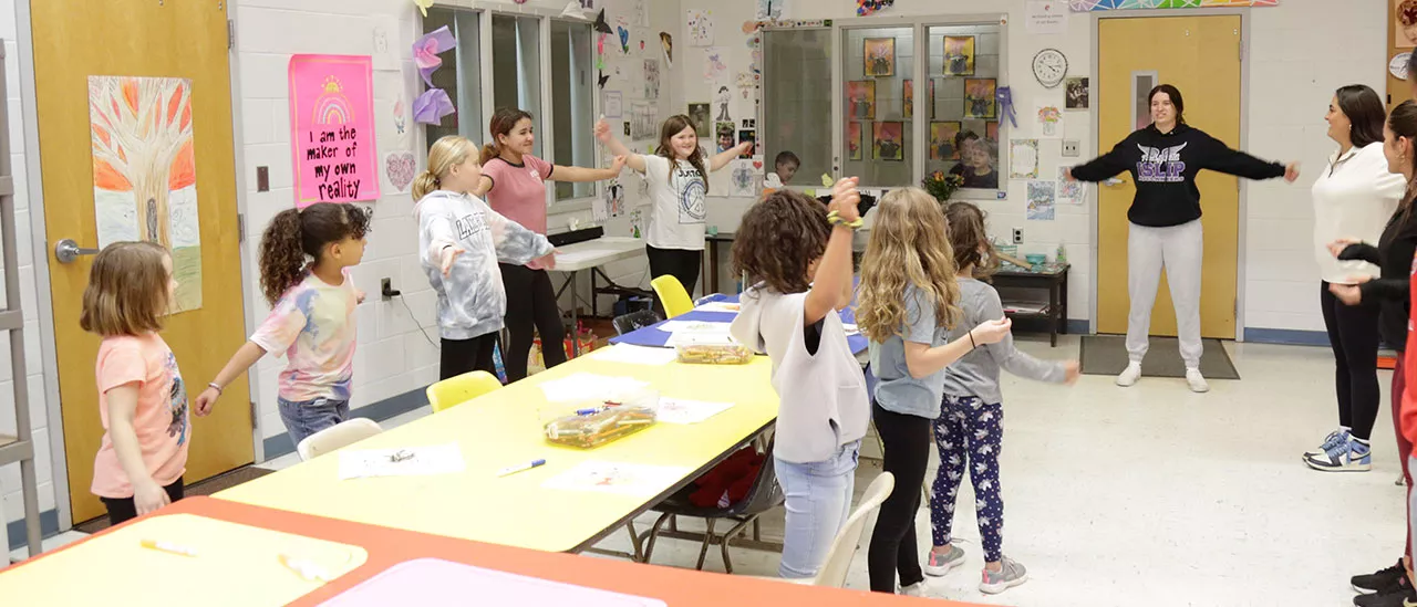 Students participating in the Little Red Dragons Program in a classroom of children.