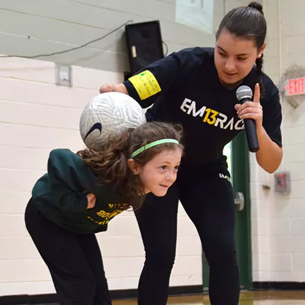 Alexia Michitti working with a child on soccer skills