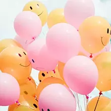 orange and pink balloons, some with smiley faces