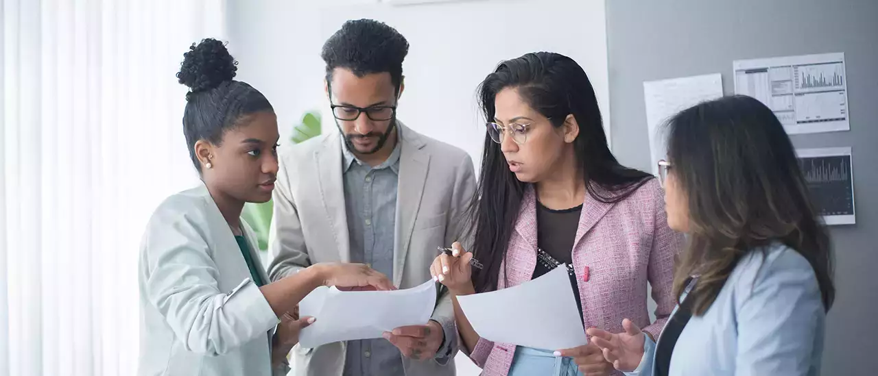 Four people discussing a report or other communication