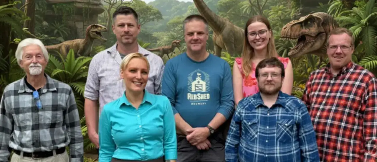 EAS Faculty Members posed in front of a prehistoric background