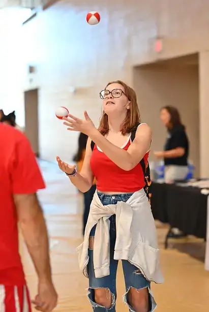A student learns to juggle during Family Weekend
