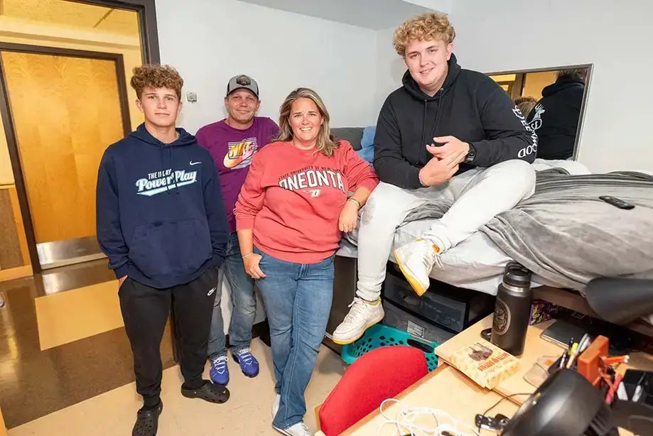 Family posing in a dorm room during move-in
