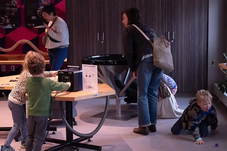Young visitors interact with an exhibit at the Science Discovery Center