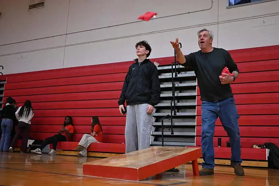 A beanbag is tossed during a cornhole game at the Spring Fling event