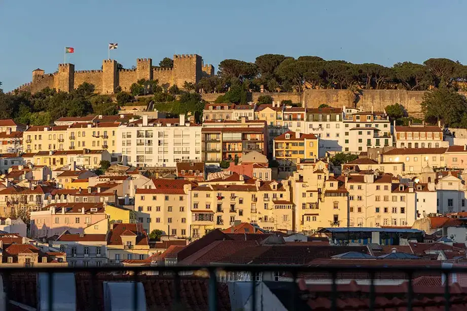 Buildings along the coast of Portugal drenched in the light of a setting sun.