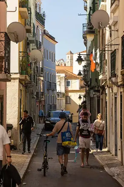An old-world city street bustles with people in Portugal.