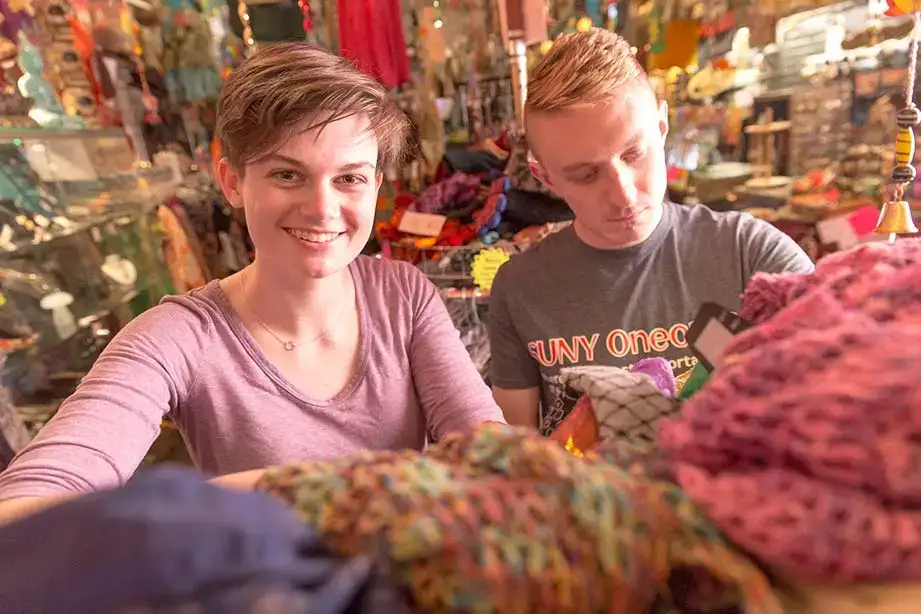 Students browse clothing items at a shop on Main Street in downtown Oneonta.