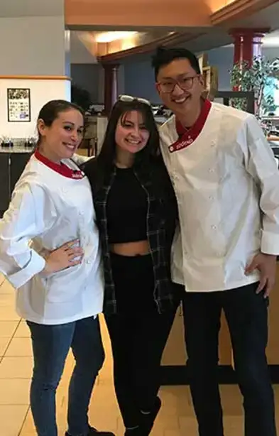 Julia and JP pose with students in Wilsbach Dining Hall.