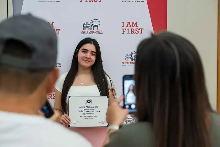 Student inductee Paola Ponce-Agredano has her photo taken by her family after the ceremony.