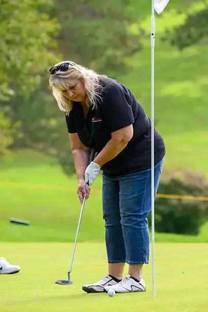 A female contestant watches as her putt moves toward the hole at the Red Dragon Open.
