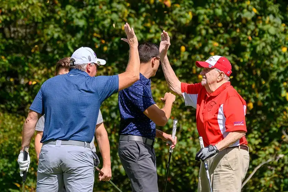 A couple of teammates give each other high-fives during the Red Dragon Open.