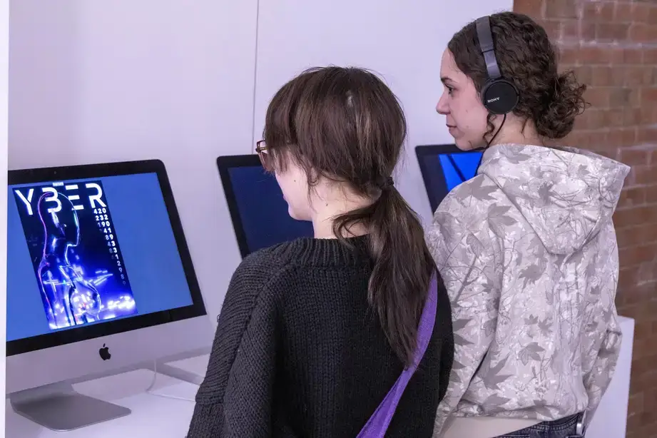 People interacting with a digital exhibit during a Juried Student Show