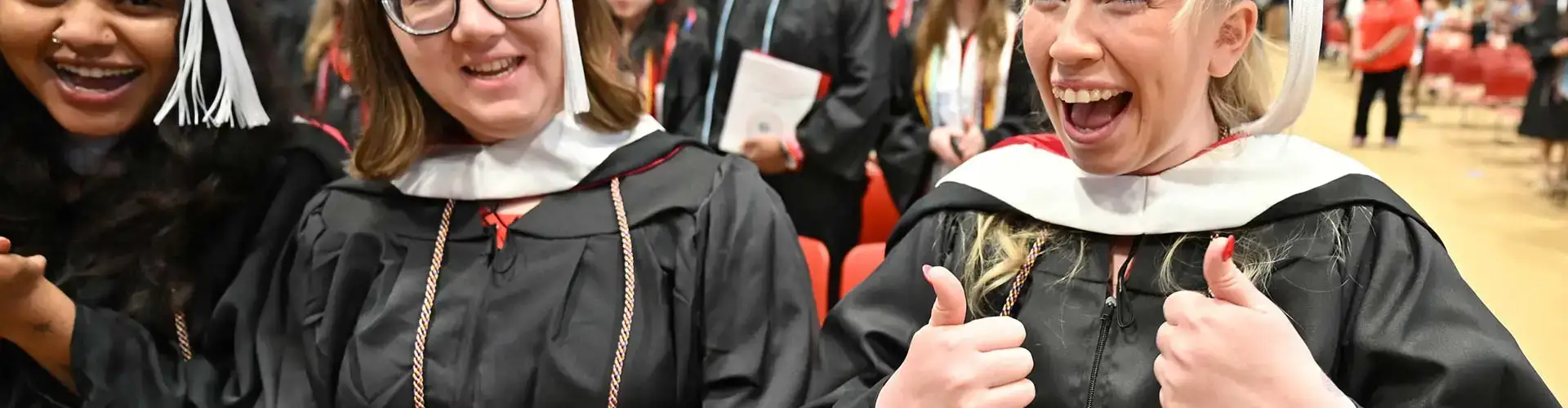 Graduates at Spring Commencement give the thumbs up