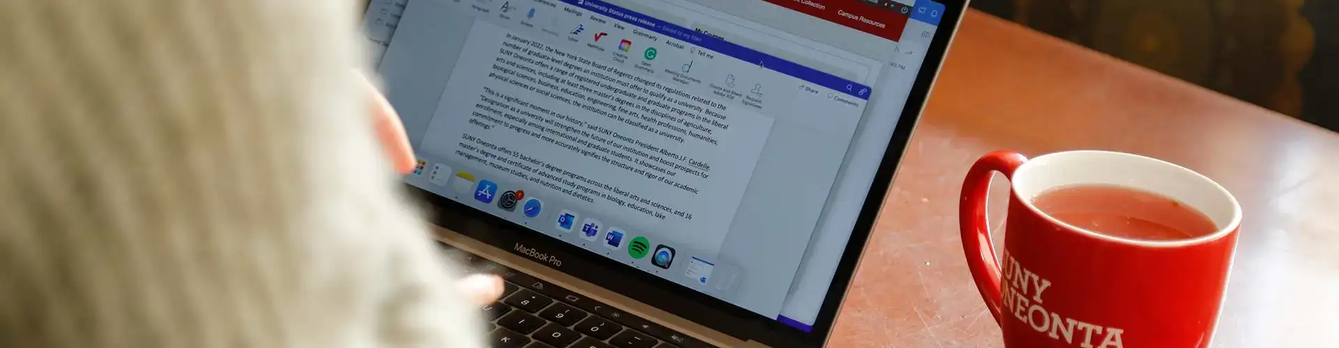 Student uses a laptop with smartphone and coffee sitting nearby