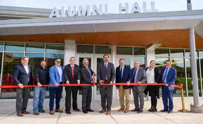 Ribbon cutting in front of rehabbed Alumni Hall, now a Platinum LEED-certified building