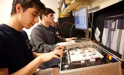 Students work on wiring CADET II trainer circuit boards to run simple programs