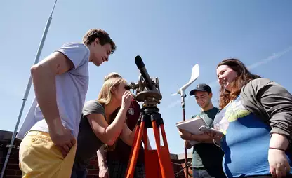 Meteorology students in a senior seminar learn how to use a theodolite