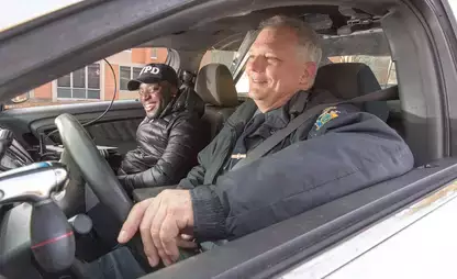 A criminal justice student rides with a University Police officer in a patrol car for first-hand experience