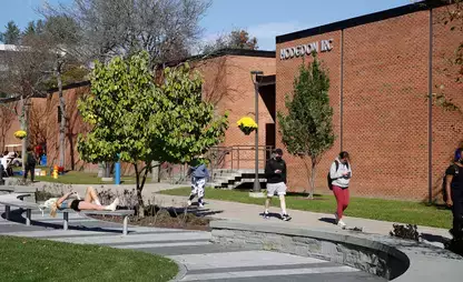 Students go about their day outside Hodgdon IRC on the SUNY Oneonta campus