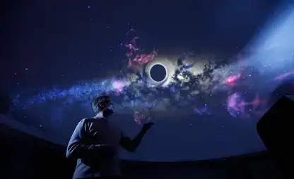 Josh Nollenberg stands underneath the digital planetarium ceiling