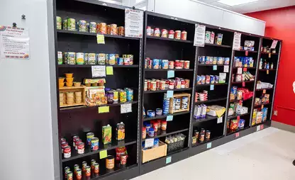 Shelves filled with food along a wall in the Red Dragon Food Pantry