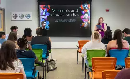 Group of students listen to lecture by Women's and Gender Studies professor.