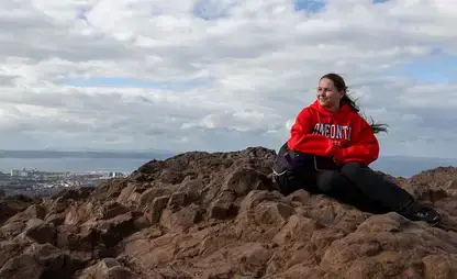 Philosophy student sits on a high bluff in Edinburgh, Scotland