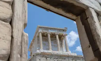 The Acropolis in Athens, Greece, framed through an ancient doorway.