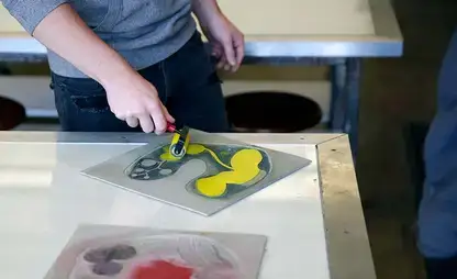 A student prepares to print a lithograph.