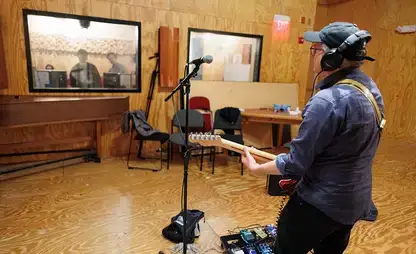 A guitarist prepares to record live in the Sudio A live room.