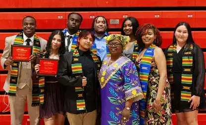 Students dressed in formal attire pose for a group photo at the 2025 Kente Graduation.