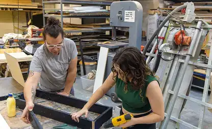 Students work with tools to assemble props in stagecraft class.