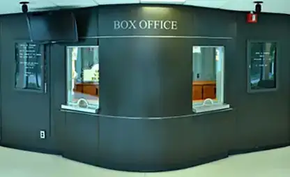 The box office features two ticket windows and couches for waiting.